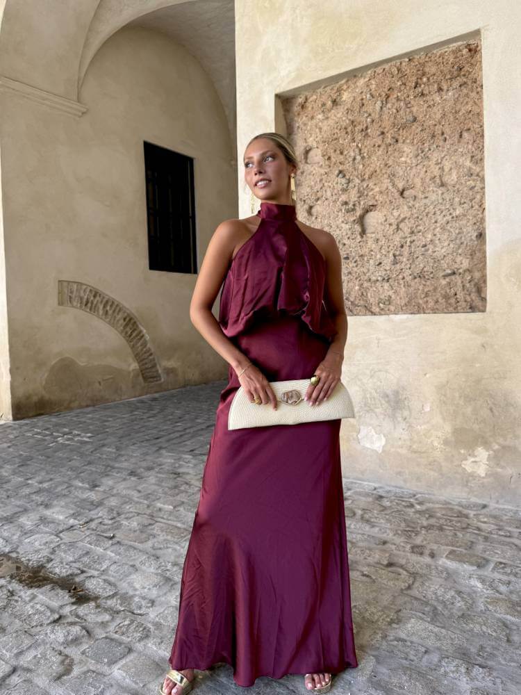 Vestido burdeos largo confeccionado en tejido sedoso con escote halter