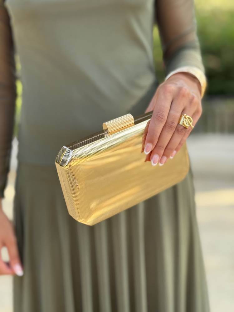 Bolso de mano dorado brillante con textura acanalada